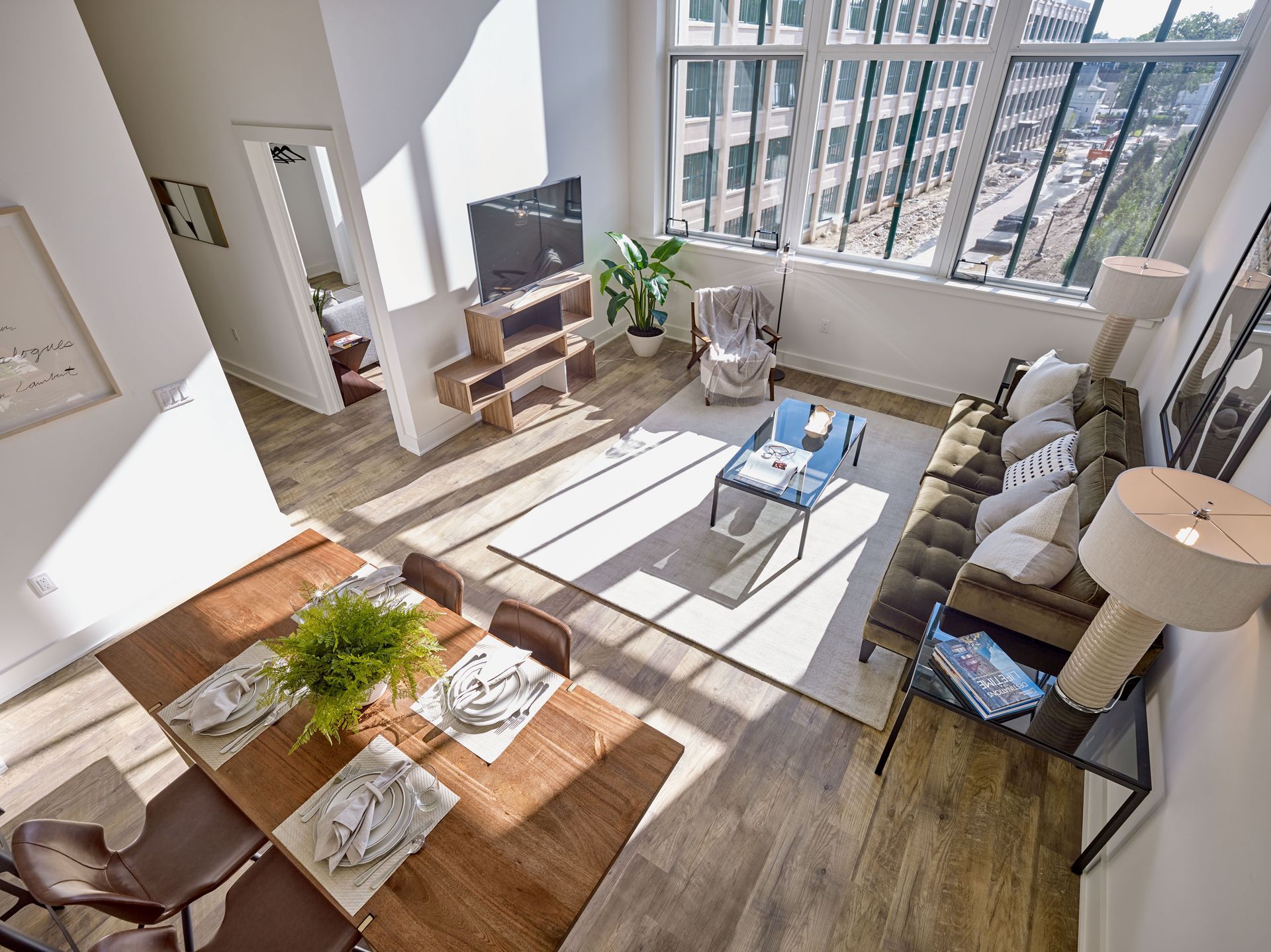 A living room with a couch, table, chairs and a television.