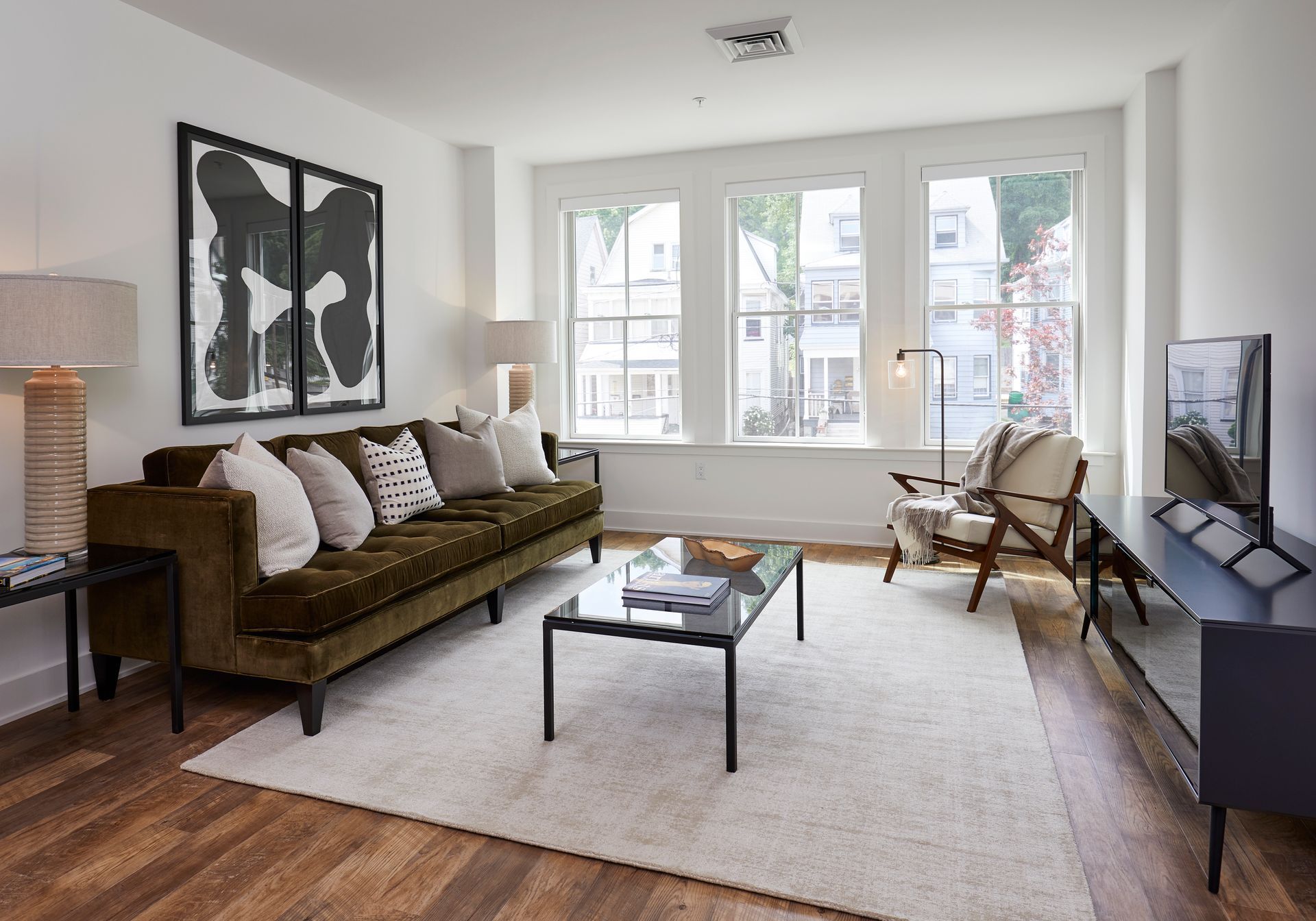 A living room with a couch, table, chairs and a television.